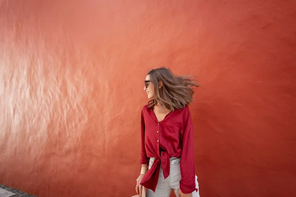 Potret seorang wanita bergaya di latar belakang dinding merah — Stok Foto