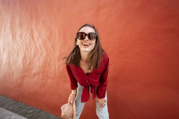 Portrait of a stylish woman on the red wall background — Stock Photo, Image