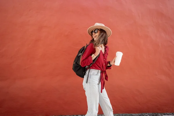 Retrato de una mujer con estilo con taza de café en el fondo de la pared roja —  Fotos de Stock