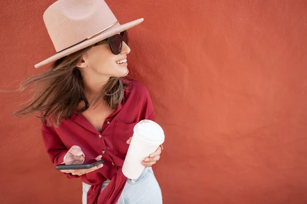 Портрет стильной женщины на фоне красной стены — стоковое фото