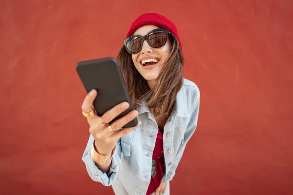 Mulher com telefone no fundo vermelho ao ar livre — Fotografia de Stock