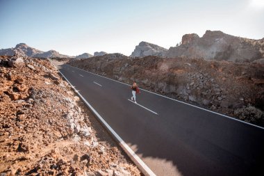 Volkanik vadide yol ve yürüyen kadın