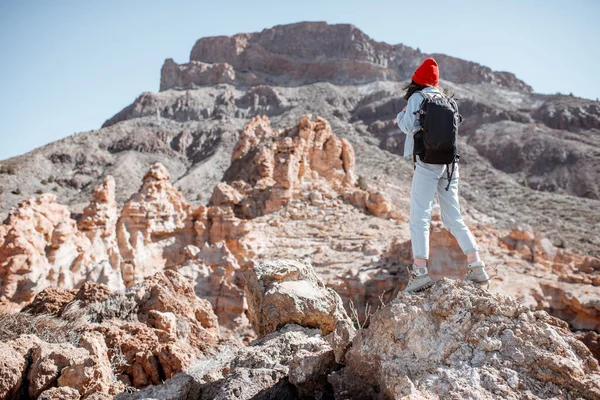 Mujer elegante caminando por el terreno rocoso mientras viaja — Foto de Stock