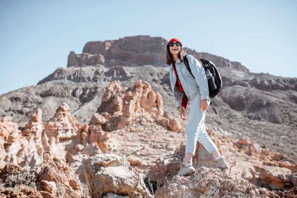 Mujer elegante caminando por el terreno rocoso mientras viaja —  Fotos de Stock