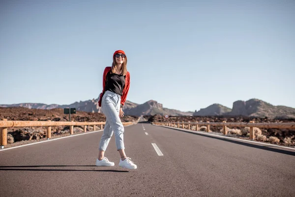 Carefree woman on the desert road — Stock Photo, Image