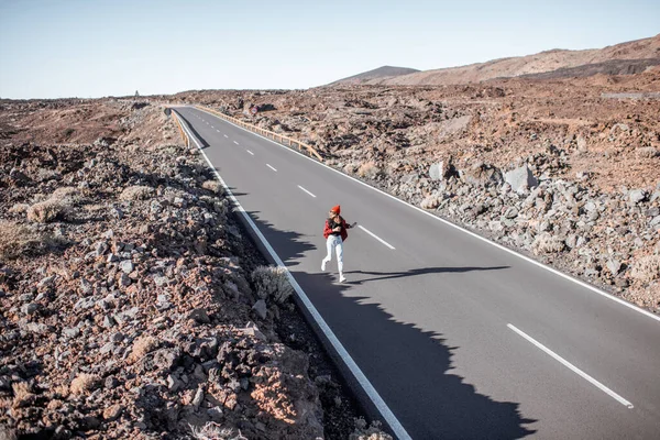 Weg op de vulkanische vallei en wandelende vrouw — Stockfoto