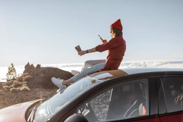 在云彩之上的岩石地形上开车旅行的女人 — 图库照片