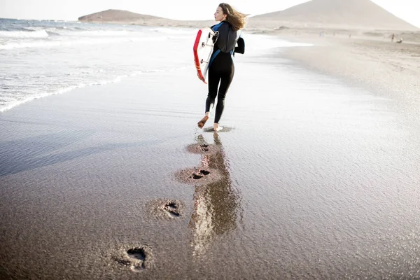 Молодой серфер с доской для серфинга на пляже — стоковое фото