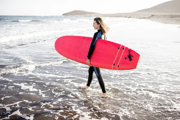 Junger Surfer mit Surfbrett am Strand — Stockfoto