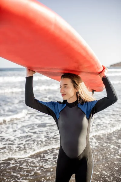 Plajda sörf tahtası olan genç bir sörfçü. — Stok fotoğraf