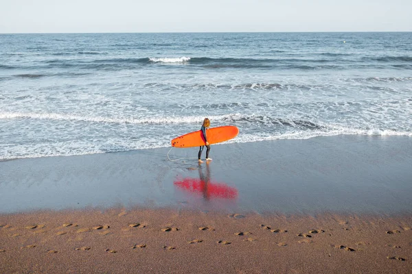 Peselancar muda dengan papan selancar di pantai — Stok Foto