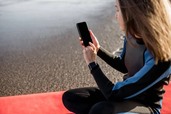 Relaxed surfer with surfboard and phone on the beach — Stock Photo, Image