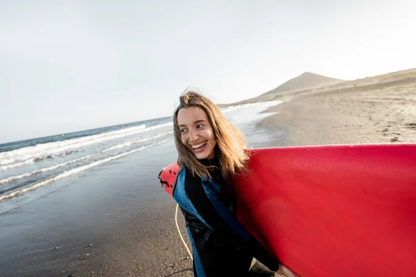 Plajda sörf tahtası olan genç bir sörfçü. — Stok fotoğraf