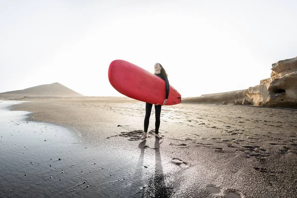 Mujer con tabla de surf en la playa — Foto de Stock