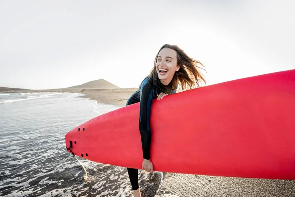 Junger Surfer mit Surfbrett am Strand — Stockfoto