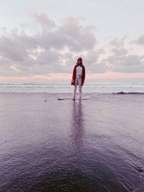 Gün batımında sahilde yürüyen kadın