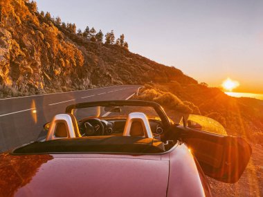 Gün batımında yol kenarında bir araba.