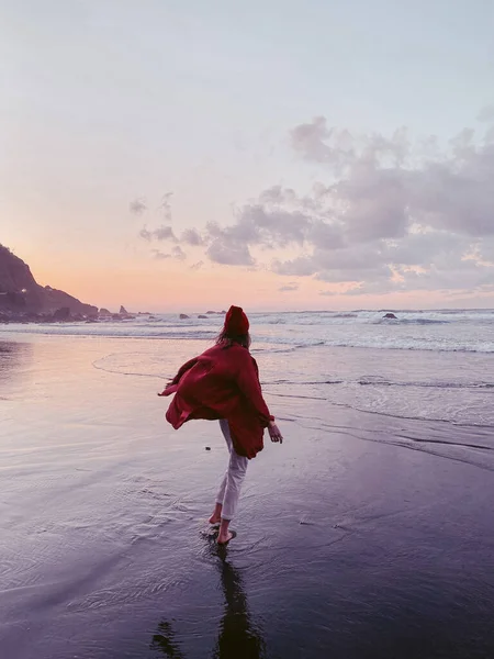 Mujer caminando en la playa al atardecer — Foto de Stock