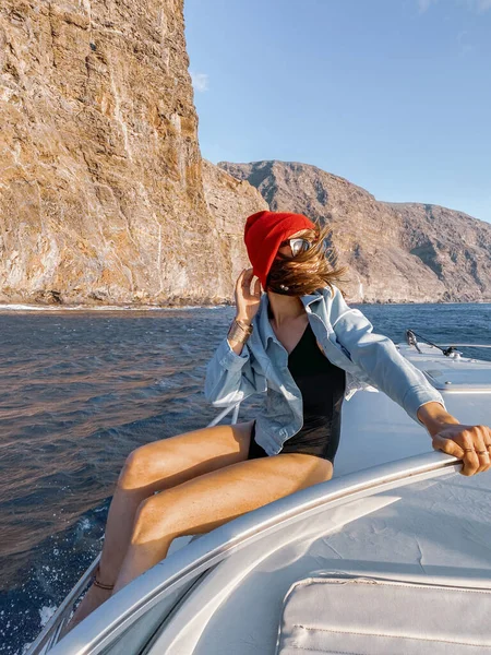Woman sailing on a yacht near rocky shore — ストック写真