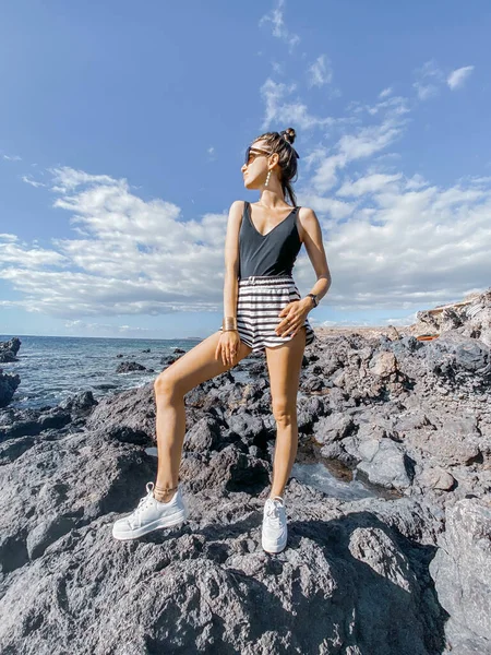 Jovem mulher na costa rochosa — Fotografia de Stock