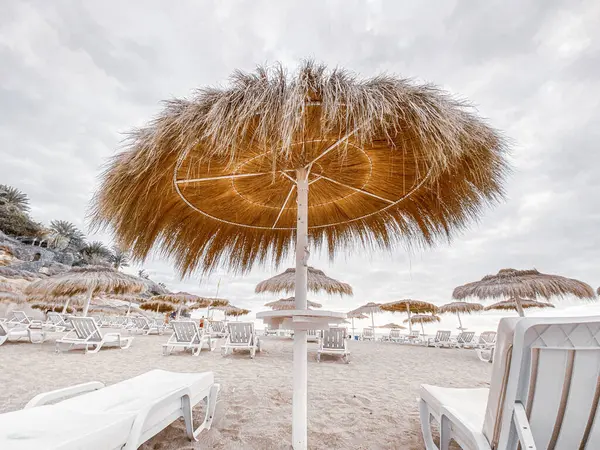 Straw umbrellas on the beach resort — Stok fotoğraf
