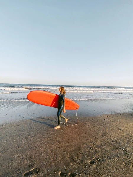 Sahilde sörf tahtası olan bir sörfçü. — Stok fotoğraf