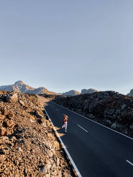 Vulkanische vallei met rechte weg en vrouw lopen — Stockfoto