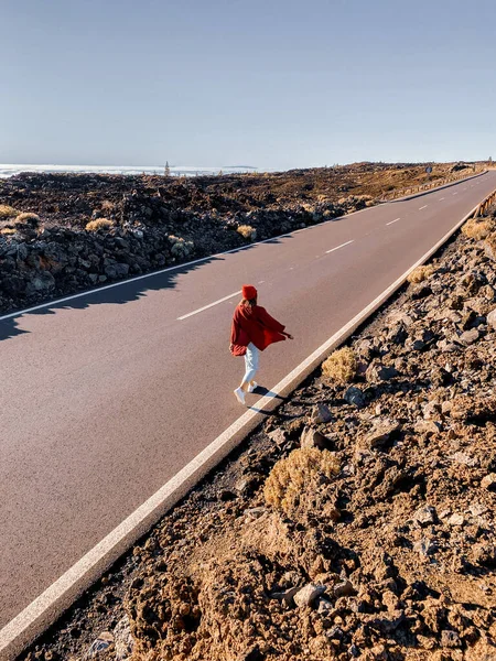 Valle volcánico con camino recto y mujer caminando — Foto de Stock