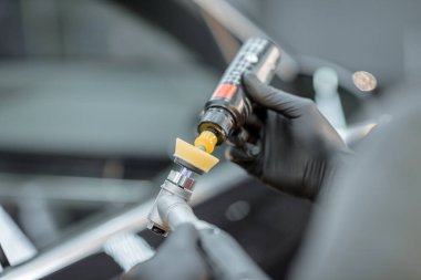 Applying wax for car body polishing