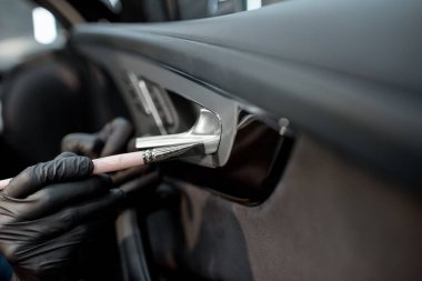 Worker provides professional car interior cleaning