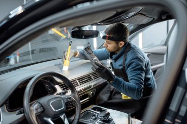 Worker provides professional car interior cleaning