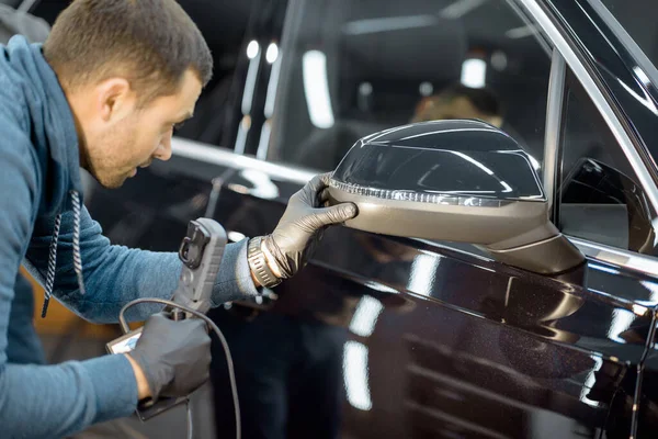 Worker examining vehicle body for scratches — Stock Fotó