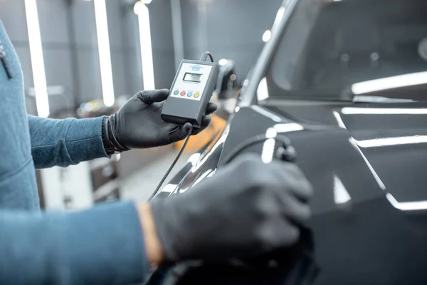 Measuring paint cover thickness of the car body at the service — 图库照片