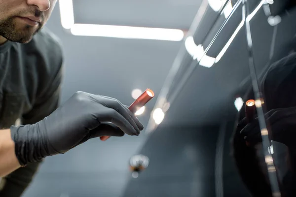 Worker examining vehicle body for scratches — Stock Fotó