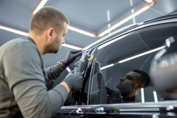 Чоловік полірує кузов автомобіля з подряпин — стокове фото