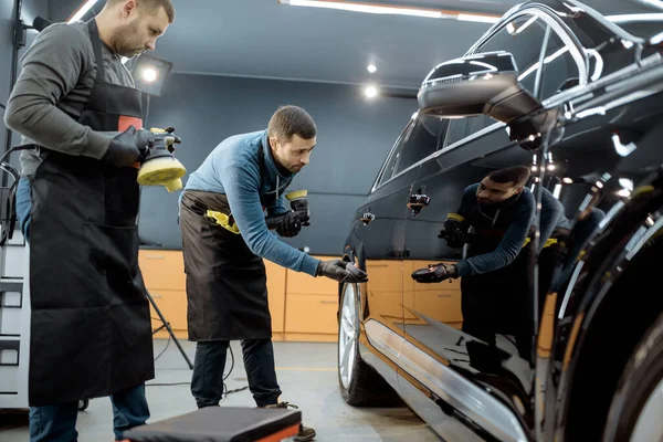 Workers examining vehicle body for scratches — 图库照片