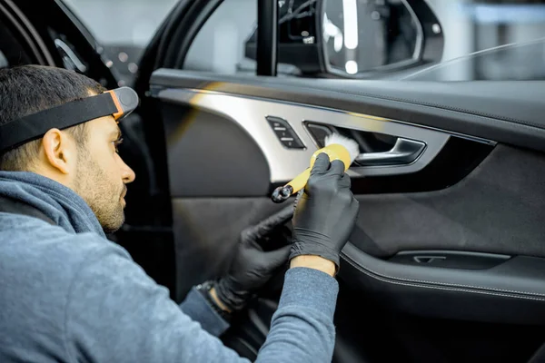 Worker provides professional car interior cleaning