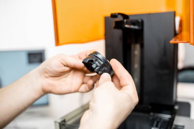 Dental technician removing jaw model from a 3d printer