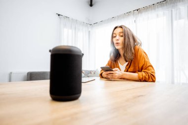 Woman controlling home devices with a voice commands