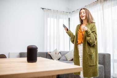 Woman controlling home devices with a voice commands