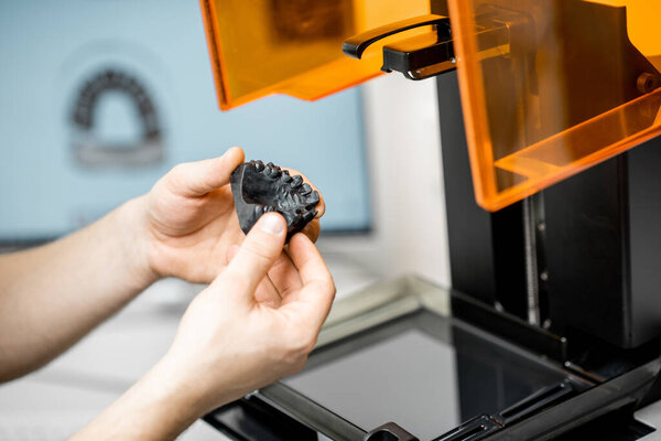 Dental technician removing jaw model from a 3d printer