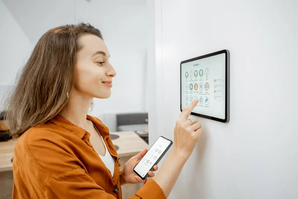 Woman controlling smart devices with a digital tablet at home — Φωτογραφία Αρχείου