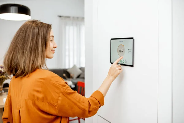 Woman controlling heating with a smart devices — 图库照片