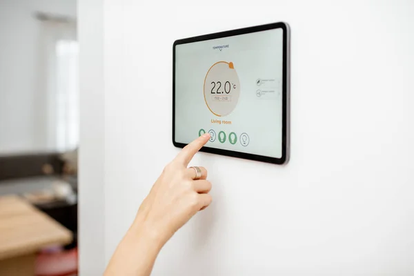 Woman controlling heating with a smart devices — Zdjęcie stockowe