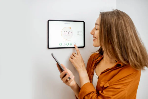 Woman controlling heating with a smart devices — Stock fotografie