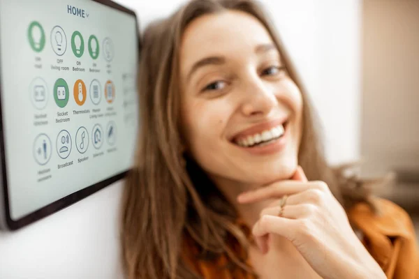 Portrait of a happy woman controlling smart home — Stock fotografie