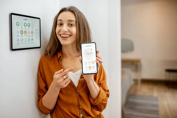 Щаслива жінка контролює розумний будинок з пристроями з сенсорним екраном — стокове фото
