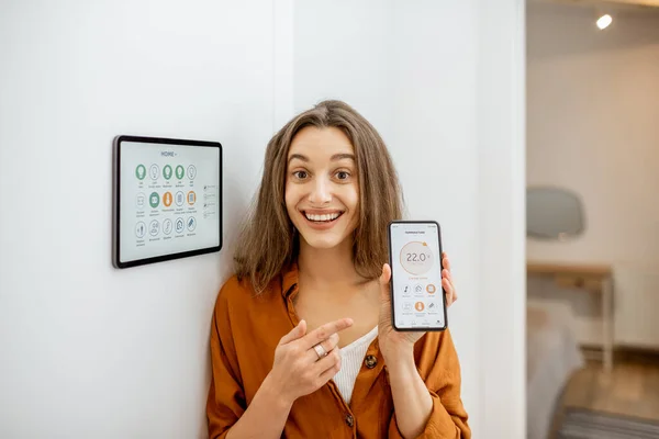 Donna felice che controlla la casa intelligente con dispositivi touch screen — Foto Stock