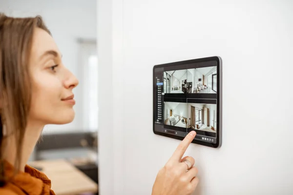 Mujer controlando el hogar con cámaras de vídeo y tableta digital — Foto de Stock