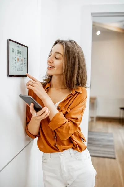Woman controlling smart devices with a digital tablet at home — Stockfoto
